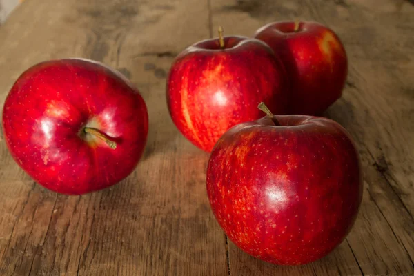 Röda äpplen på en trä bakgrund — Stockfoto