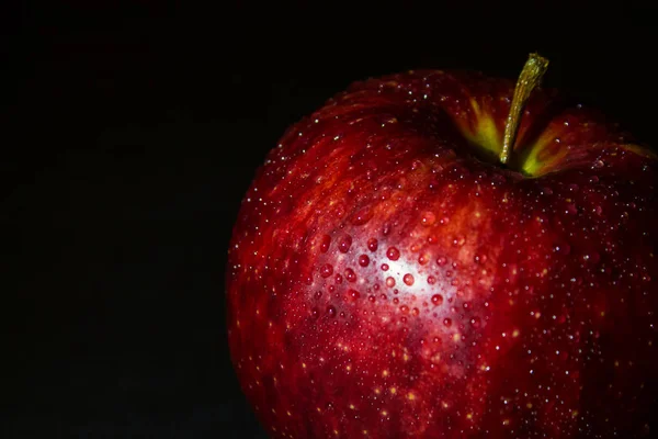 Nassen roten Apfel in Wassertropfen auf einem schwarzen — Stockfoto