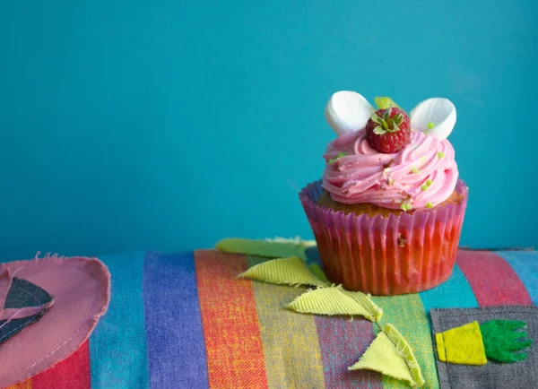 Delicioso cupcake em um tapete de lugar colorido descascado têxtil, horizontal com espaço de cópia . — Fotografia de Stock