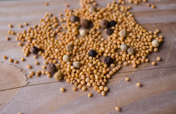 Spicy mustard seeds in a wooden background. Organic mustard seeds on brown table. Assorted spices for cooking on the wood surface — Stock Photo, Image