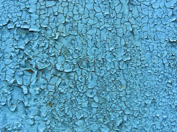 Old cracked paint pattern on wall. Peeling paint. Pattern of rustic blue grunge material. Damaged paint. Wall covered with cracked paint. Flaking paint on a concrete wall. Scratched old surface