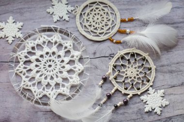 Dreamcatcher ahşap arka plan üzerinde tüyleri ile. Etnik tasarım, boho tarzı, kabile simgesi. Eski ahşap antika arka plan üzerinde beyaz Noel ve yeni yıl kar tanesi.