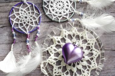 Dreamcatcher ahşap arka plan üzerinde tüyleri ile. Etnik tasarım, boho tarzı, kabile simgesi.