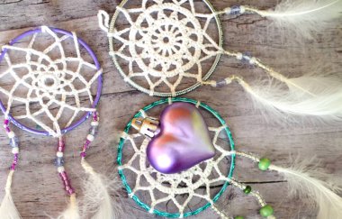 Dreamcatcher ahşap arka plan üzerinde tüyleri ile. Etnik tasarım, boho tarzı, kabile simgesi.