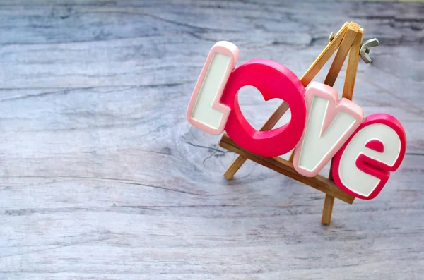 Декоративная надпись Любовь на небольшом деревянном мольберте, который стоит в винтажной доске — стоковое фото