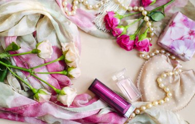 Photocomposition pastel renklerde hafif bir vintage tarzı. Çay ve pembe Gül inciler, rujlar, parfüm tarafından çevrili bir İpek eşarp, yalan. Fotoğraf bir iletiye bir kadın için bir çerçeve olarak hizmet verebilir.