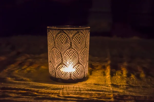 Glass candlestick patterned glowing in the dark .