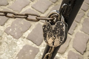 Eski patikaların arka planındaki zincirde asma kilit. Eski kasaba fotoğrafı. .