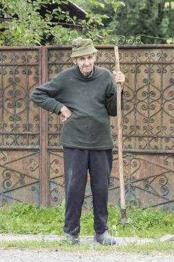 Bir adam Romanya'da dirgen ile