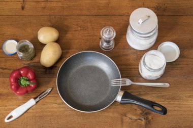 ahşap bir masa üzerinde bir tavada sebze hazırlama