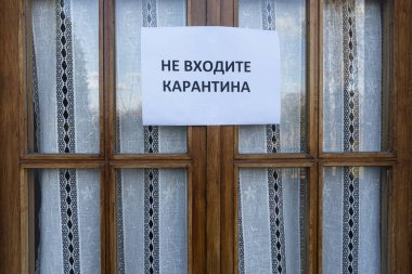 Bir pencereye bağlı Rusça karantinaya girmeyin yazan bir tabela