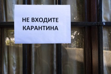 Bir pencereye bağlı Rusça karantinaya girmeyin yazan bir tabela