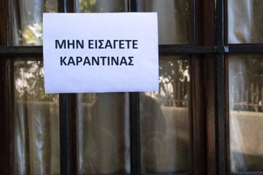 Girilmez yazan bir tabela, pencereye Yunan dilinde karantina