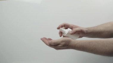 Bir adam ellerini COVID-19 'a karşı dezenfektanla dezenfekte ediyor.