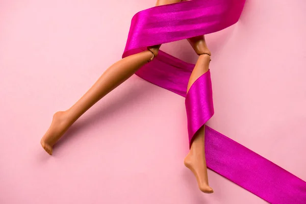 Κοντινό Πλάνο Λείων Ποδιών Μιας Πλαστικής Κούκλας Παιχνιδιών Ροζ Σατέν — Φωτογραφία Αρχείου