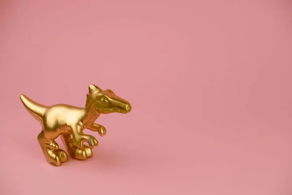 Goldene Dinosaurier Statuette Auf Pastellrosa Hintergrund Mit Kopierraum Trendige Minimal — Stockfoto