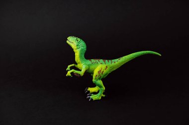 Siyah arka planda izole edilmiş yeşil plastik dinozor oyuncağı