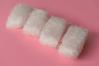 Pembe arka planda Asyalı pişmemiş selofan erişteler.