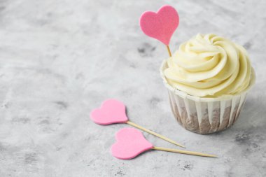 Gri beton bir masada pembe kalpli kapkeki kapat.