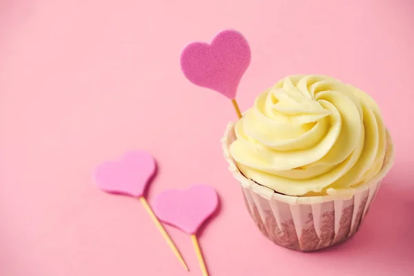 close up cupcake with pink heart on a a pastel pink background with copy space