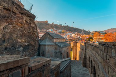 Tiflis, Gürcistan, 17 Aralık 2019 - şehir manzarası renkli evler, Narikala kalesi, ana Gürcistan anıtı ve Metekhi Tapınağı 'nın duvarlarından geçen kablolu yol.