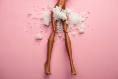 plastic doll legs with snow covered  crotch on  pastel pink background clipart
