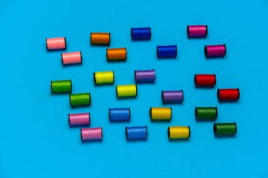 Üst görünüm yaratıcı natürmort mavi arkaplan üzerinde çok renkli iplik desenleri ile yatıyordu