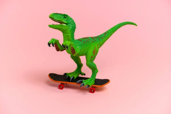 Niedlichen Grünen Dinosaurier Spielzeug Mit Schlittschuh Isoliert Auf Einem Rosa — Stockfoto