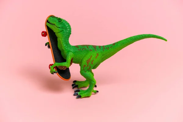 Niedlichen Grünen Dinosaurier Spielzeug Mit Schlittschuh Isoliert Auf Einem Rosa — Stockfoto