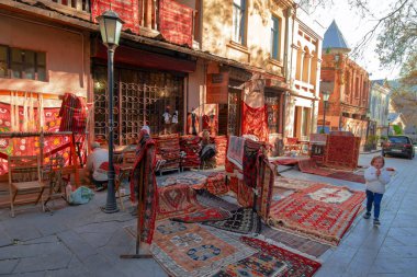 Tbilisi, Georgia, 17 December 2019 -  Oriental vintage carpets on the street in front of the entrance to the carpet gallery