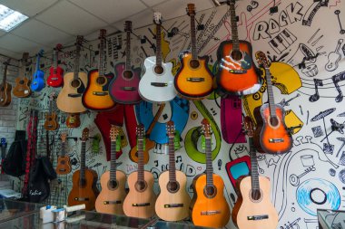 Brüksel, Rusya, 23 Aralık 2019. Bir müzik mağazasının duvarında bir sürü akustik gitar ve gitar asılı.