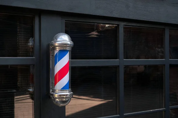Barbershop pole against black wal