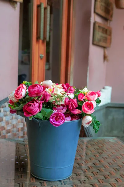 colorful roses in a bucket on the table
