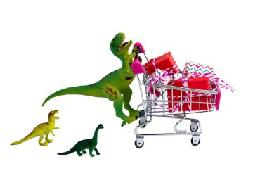 Alışveriş arabası hediye kutularıyla dolu komik yeşil dinozor oyuncağı ve beyaz arka planda izole edilmiş küçük dinozor çocukları.