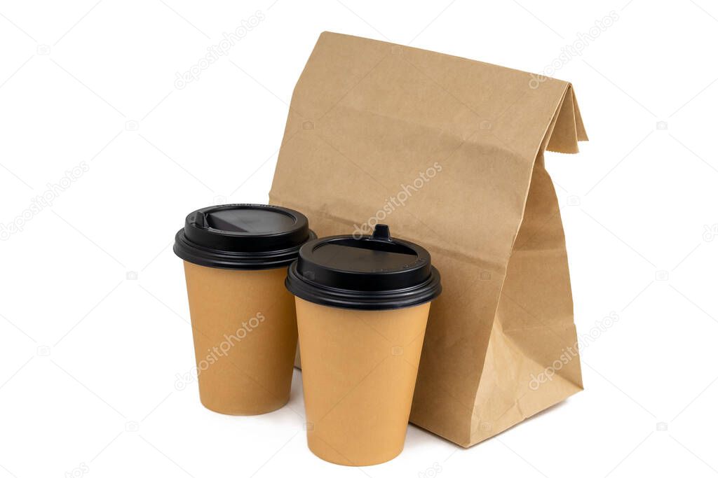 two disposable paper cups and a paper bag with food isolated on a white background