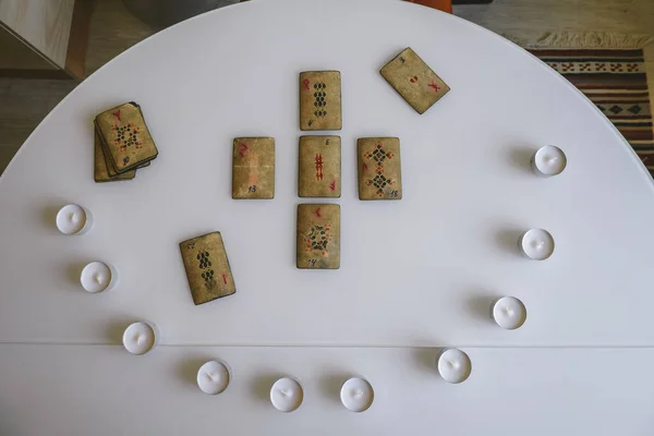 トップ表示白いテーブルの上にランのシンボルとキャンドルの円を持つフラットレイヴィンテージカード — ストック写真