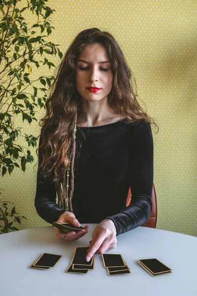 Hermosa Mujer Joven Vestido Terciopelo Negro Pone Tarjetas Sobre Mesa —  Fotos de Stock