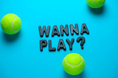 Üst manzara düz tenis topları ve yazıtlar parlak mavi bir arka planda oynamak istiyor.