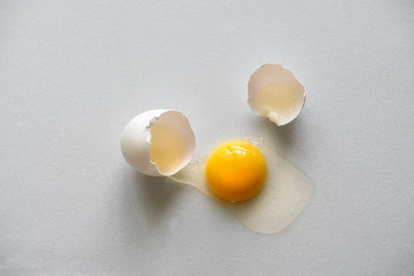 top view cracked egg shell and raw egg on a white background