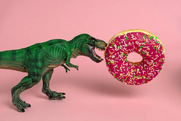 Funny card with dinosaur with open mouth bites strawberry donut on a pink background — Stock Image Funny Card Dinosaur Open Mouth Bites Strawberry Donut Pink Background Royalty Free Stock Images