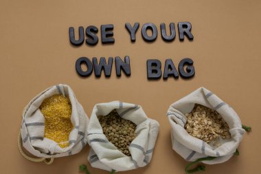 Tekstil poşetlerindeki mısır gevrekleri bej arka planda düzdü, sıfır atık ve plastik torba konsepti yoktu.