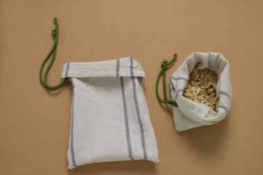 Üst görünüm boş tekstil torbası ve yulaf ezmesi bej bir zemin üzerinde yatıyordu, sıfır atık ve plastik torba konsepti yoktu.