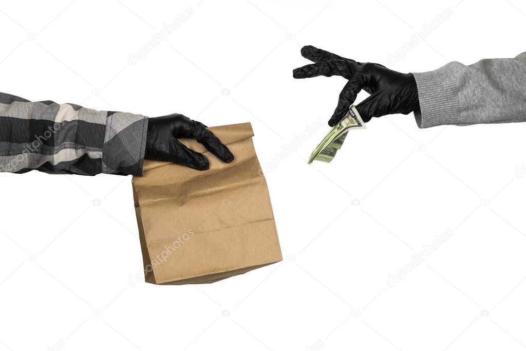 courier's hand in latex gloves holds a paper mock  up bag with food and female hand in latex gloves gives him