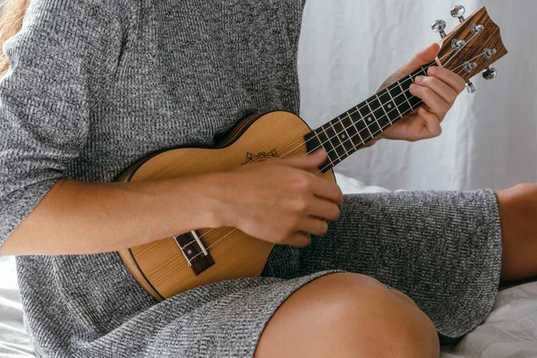 close up female hands with ukulele hawaiian guitar