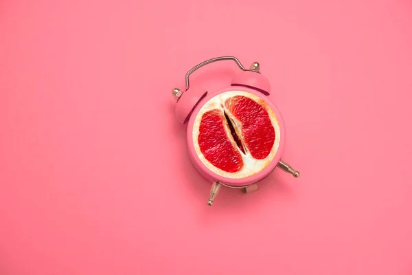 Saat ve greyfurtlu kolaj ve pembe arka planda seks için yazma zamanı