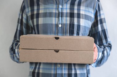 Elinde pizza kutusu olan adam, teslimat konsepti.