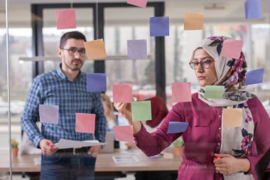 İş iş arkadaşları fikirler cam duvar stic ile görüşüyorlar