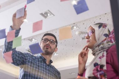 İş iş arkadaşları fikirler cam duvar stic ile görüşüyorlar