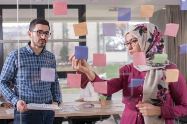 İş iş arkadaşları fikirler cam duvar stic ile görüşüyorlar