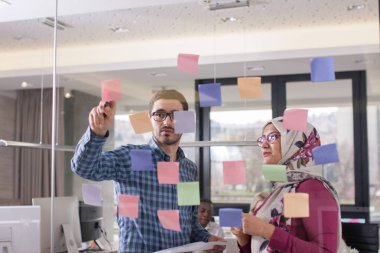 İş iş arkadaşları fikirler cam duvar stic ile görüşüyorlar